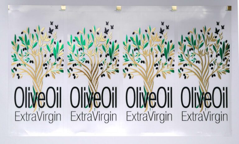 Photo of olive oil food labels, with text embellished in varnish and trees in green and gold gilding - printed and embellished on an MGI Digital Technology press