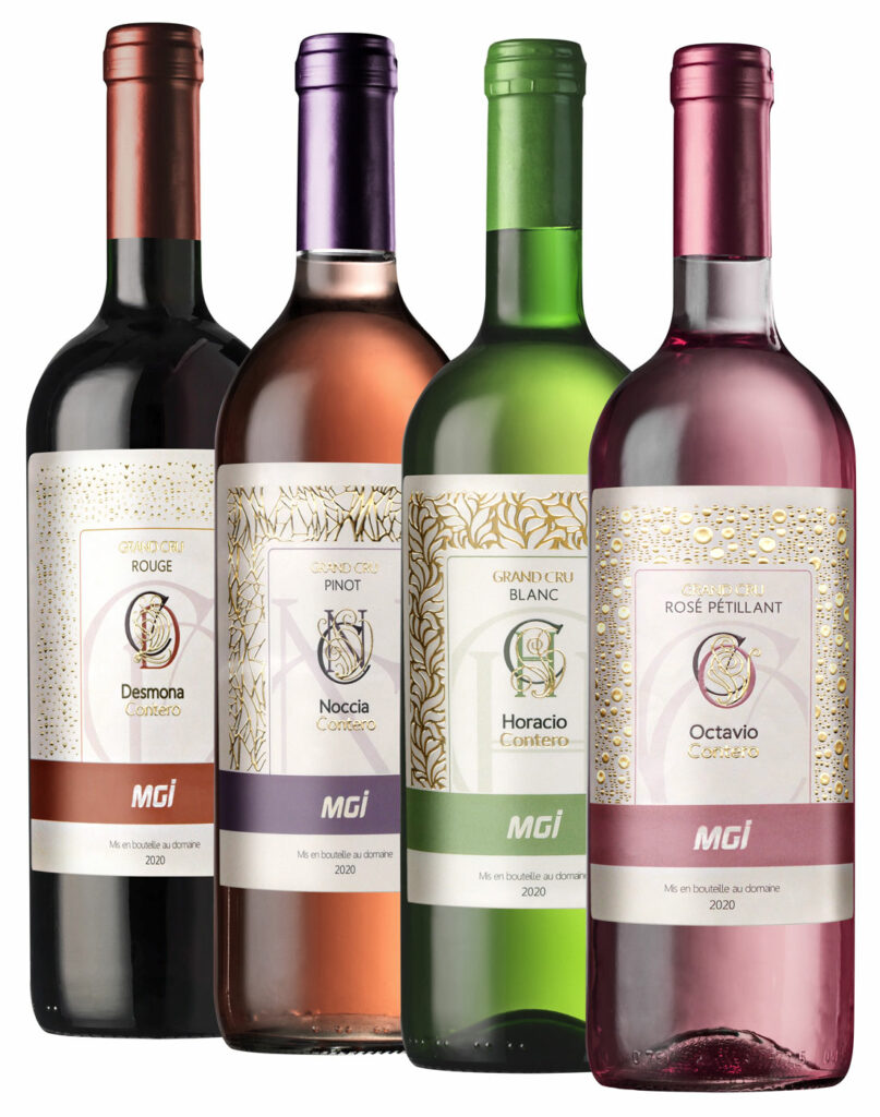 Photo of wine labels on bottles with an embellished monogram in gilding and varnishing, as well as various geometric textures in gilding