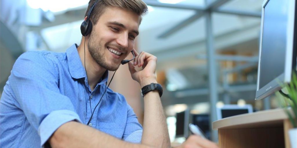 photo of a man speaking into a microphone with a headset